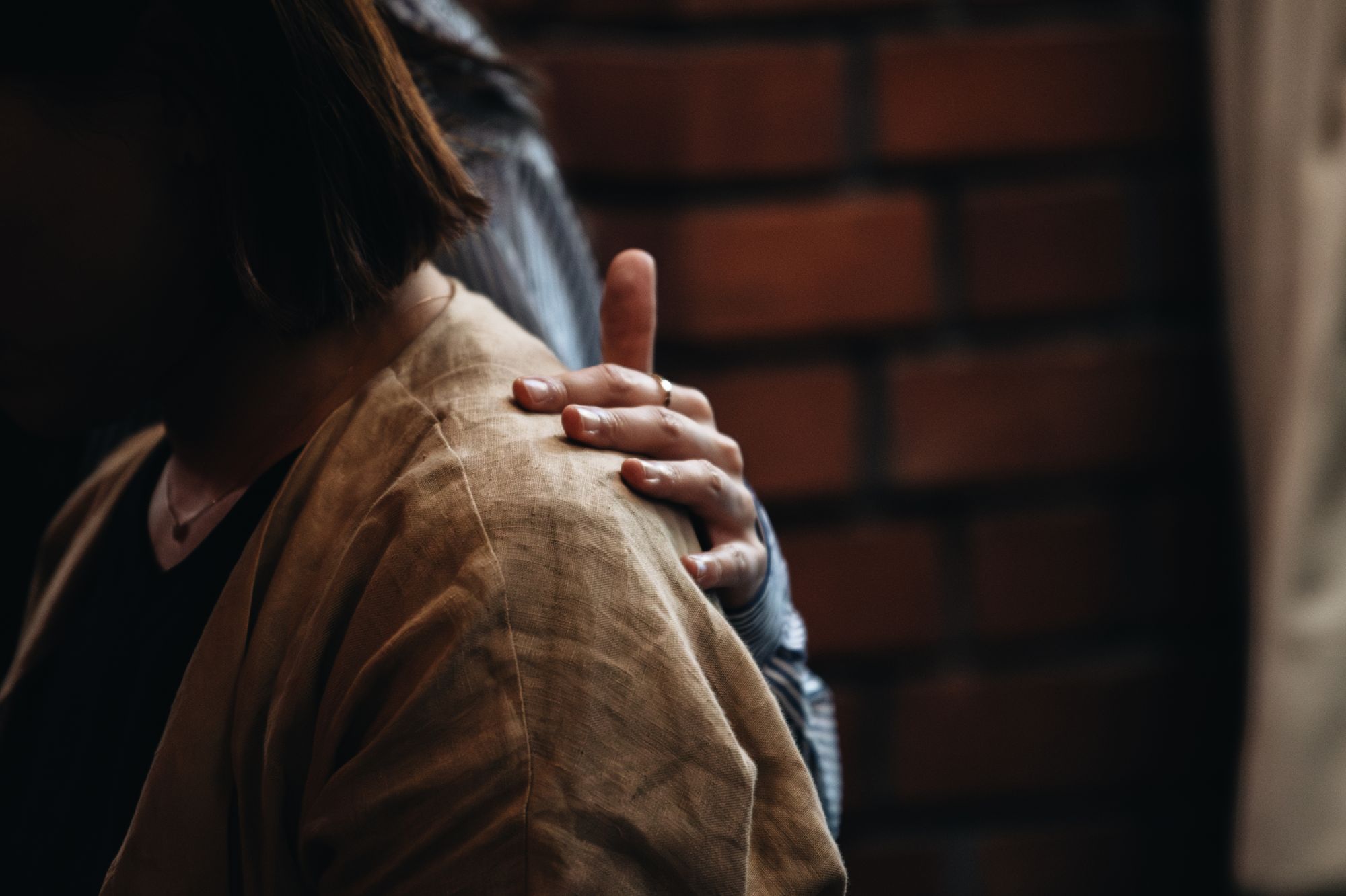 A reassuring hand resting on someone's shoulder
